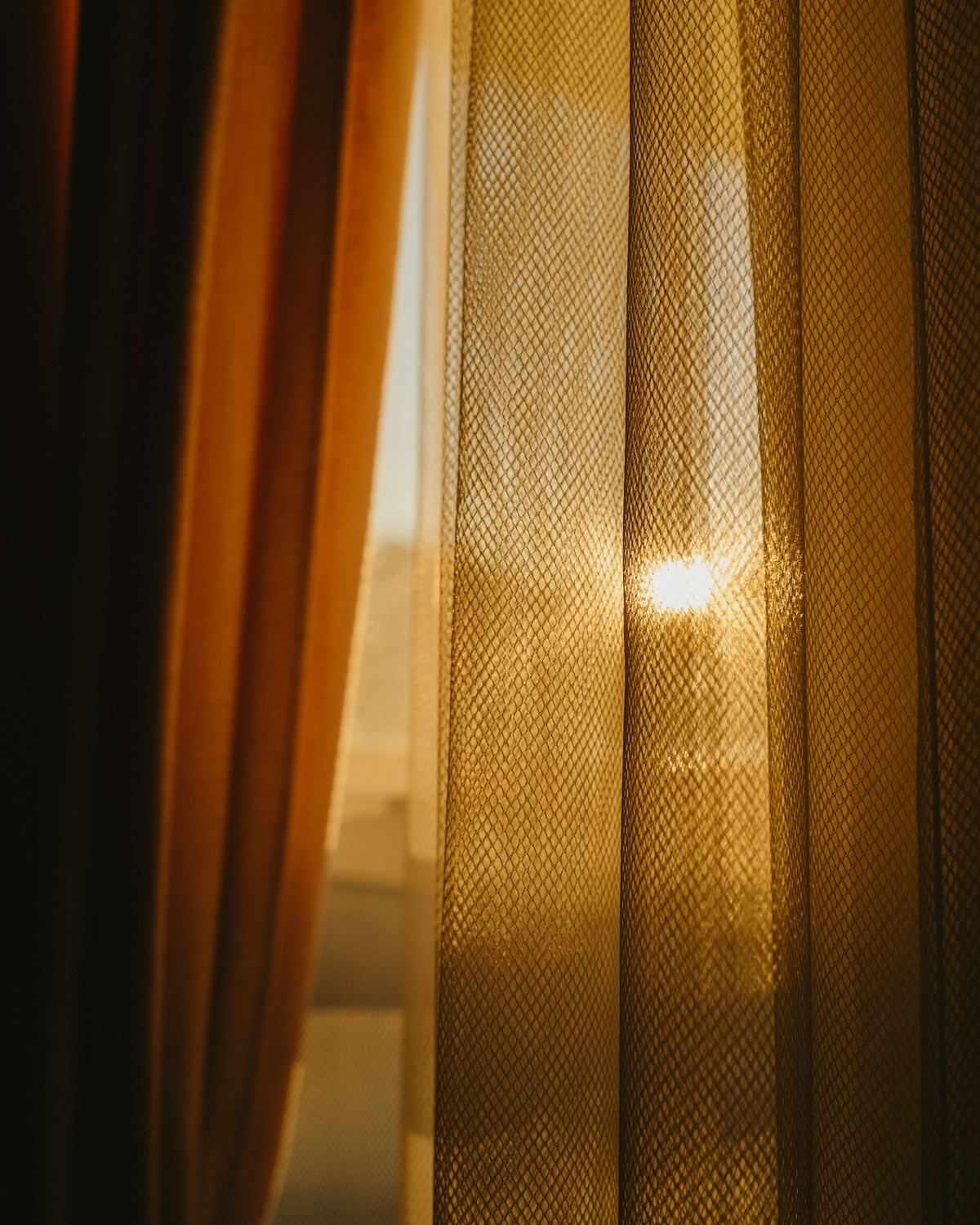 Morning sunlight glowing through sheer curtains